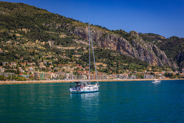Mediterranean Sea and coastline with a beach and a boat in the water in Menton on the French...