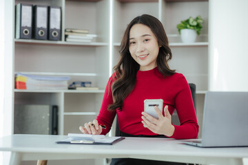 Beautiful Asian woman working on laptop in home office