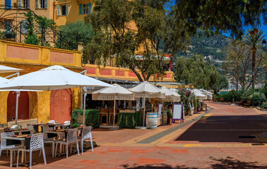 Outdoor tables waiting for customers at a street cafe near the farmers market in the Old Town, Vieille Ville in Menton, French Riviera South of France