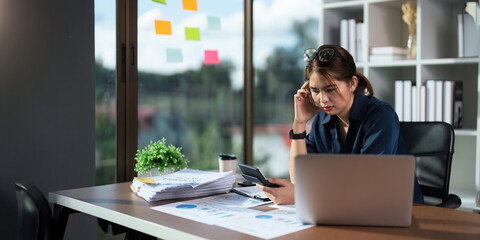 Overworked businesswoman financier while working on laptop and tablet at office