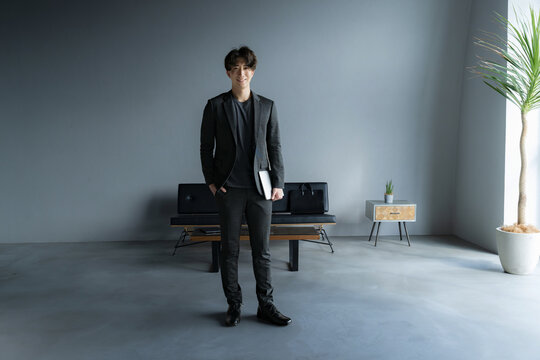 Handsome man standing in a dark room with a computer