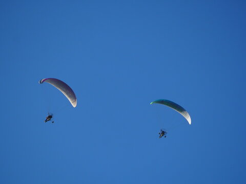 dos parapentes sobrevolando las murallas chinas de finestres bajo un cielo azul radiante, vela fija de color blanco y negro, motor de h&eacute;lice y piloto, huesca, arag&oacute;n, espa&ntilde;a, europa 