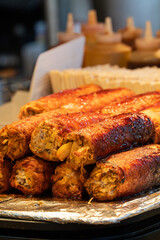Grilling barbecue meatloaf rolled with vegetables at traditional night market in South Korea.