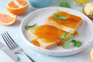 Sandwiches with marmalade, orange juice and coffee ready for breakfast