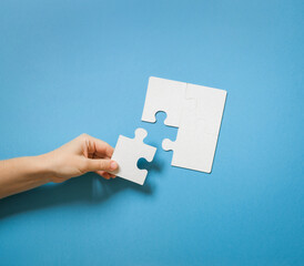 parts of white puzzle detail on blue background with copy space. mockup. unification, joint problem solving, connection and description of parts of whole