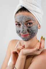 pretty sexy woman applying clay black mask on white background