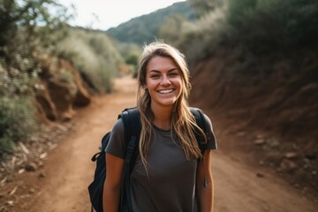 a young woman smiling while standing on a trail