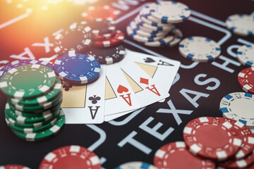 Four Ace playing cards with chips on casino table