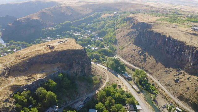 Forward reveal aerial shot of Bjni Fortress on sunny summer day. Bjni village, Kotayk Province, Armenia.