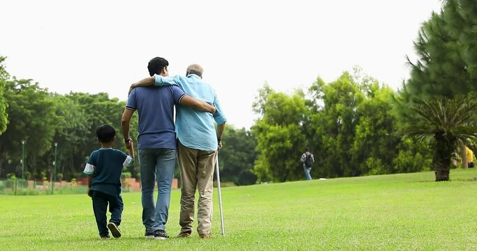 Video of back view of Male Multi Generation Family Walking In Park
