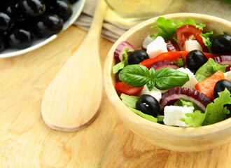 Greek salad with olives in a wooden bowl