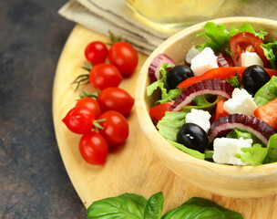 Greek salad with olives in a wooden bowl