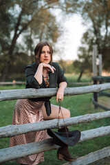 A beautiful girl dressed in country style walks in the park