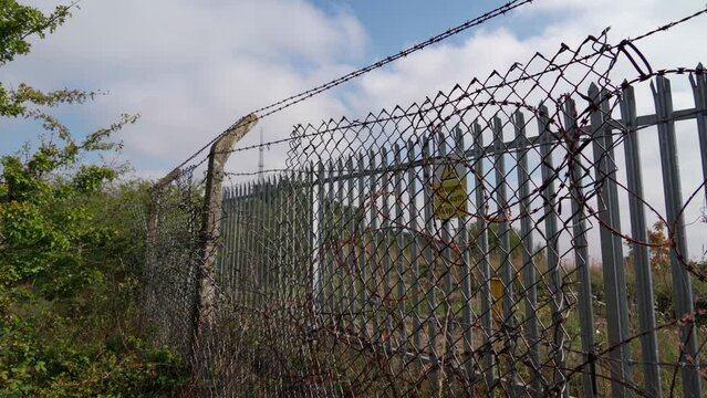 A security fence with bars, warnings and barbed wire