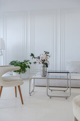 interior of a bright living room in a luxurious baroque style with white walls decorated with antique stucco