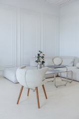 interior of a bright living room in a luxurious baroque style with white walls decorated with antique stucco