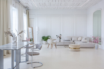 marble dining table and two chairs against the backdrop of a panoramic window into the interior of a bright living room in a luxurious Baroque style with white walls decorated with antique stucco