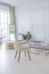 interior of a bright living room in a luxurious baroque style with white walls decorated with antique stucco