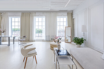 interior of a bright living room in a luxurious baroque style with white walls decorated with antique stucco