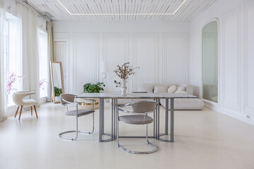 interior of a bright living room in a luxurious baroque style with white walls decorated with antique stucco