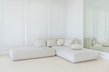 interior of a bright living room in a luxurious baroque style with white walls decorated with antique stucco