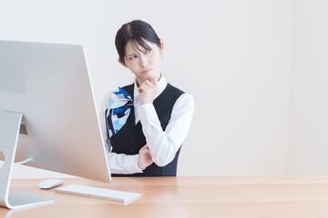 パソコンを使う考える女性スタッフ