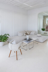 interior of a bright living room in a luxurious baroque style with white walls decorated with antique stucco