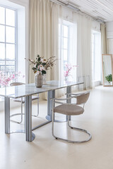 marble dining table and two chairs against the backdrop of a panoramic window into the interior of a bright living room in a luxurious Baroque style with white walls decorated with antique stucco