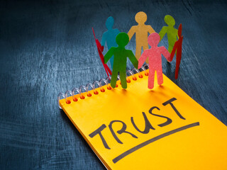 Paper men and notepad with the inscription trust.