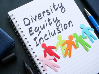 A Notepad with inscription diversity, equity and inclusion and paper men.