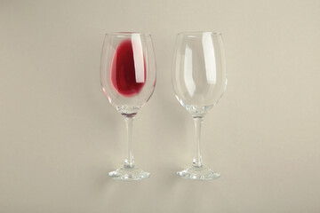 Glasses with red wine lying on grey background, top view. Flat lay