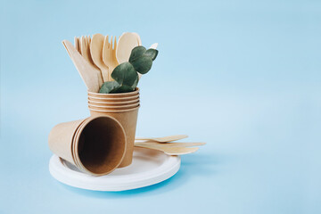 eco friendly tableware set. Kraft paper utensils, paper containers and cups on blue background. Street food paper packaging and now waste concept