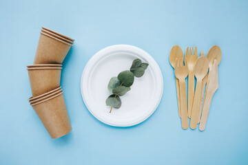 eco friendly tableware set. Kraft paper utensils, paper containers and cups on blue background. Street food paper packaging and now waste concept