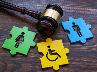 Gavel with puzzle pieces. Disabled person sign as symbol of inclusion.