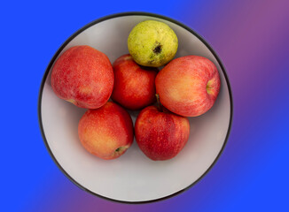 Red apples in white ceramic plate, macro shot, isolated on colored background.