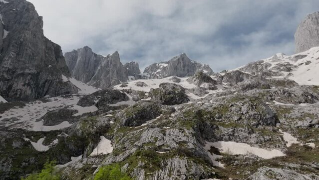 rocky mountain landscape, summer sunny day. ridges with a white snow. move left. 