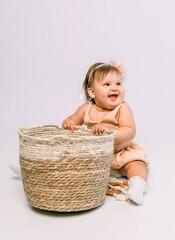 little girl sitting in a dress on a white background in the studio