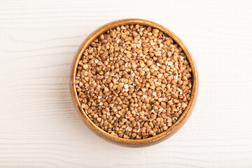 Raw buckwheat on white wooden, top view