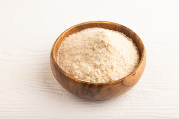 Powdered milk and buckwheat baby food mix, on white wooden, side view