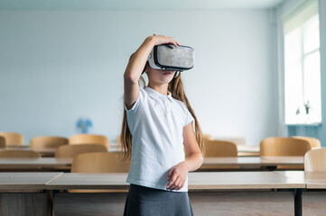 Caucasian schoolgirl wearing virtual reality glasses in the classroom. 