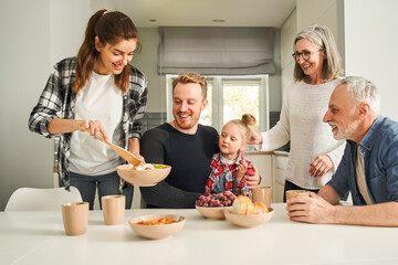 Happy family enjoying each other while having lunch together in dining room