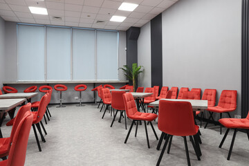 office dining room, red chairs and gray tables, artificial plant in the corner