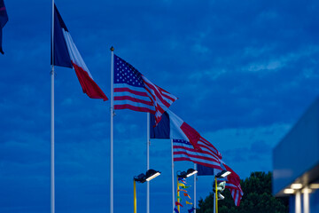 Waving country flags at fun park at Giens Peninsula on a cloudy late spring night. Photo taken June 9th, 2023, Giens, Hy&egrave;res, France.