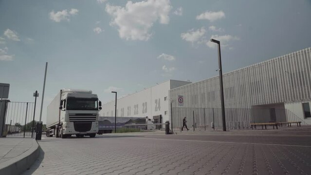White truck leaves the warehouse after being loaded with goods