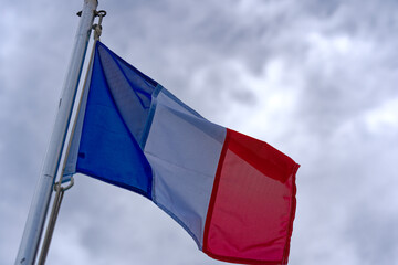 French flag waving at harbor of Toulon on a cloudy late spring day. Photo taken June 9th, 2023,...