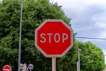 Stop sign at village Giens with trees in the background on a cloudy late spring day. Photo taken...
