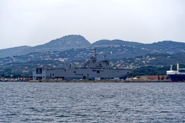 Moored warships with helicopter carrier Dixmude L-9015 at French Navy Naval Base at City of Toulon on a cloudy late spring day. Photo taken June 9th, 2023, Toulon, France.