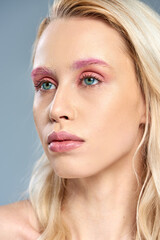 Fototapeta premium close up, woman with pink eye makeup and blue eyes looking away on grey backdrop, feminine beauty
