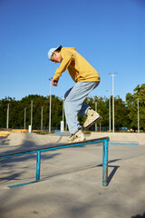 Talented teen guy roller skating making trick on border