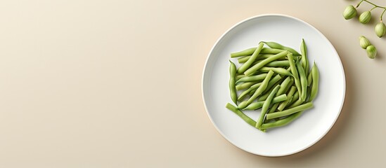 A closeup of green beans on a white plate on isolated pastel background Copy space